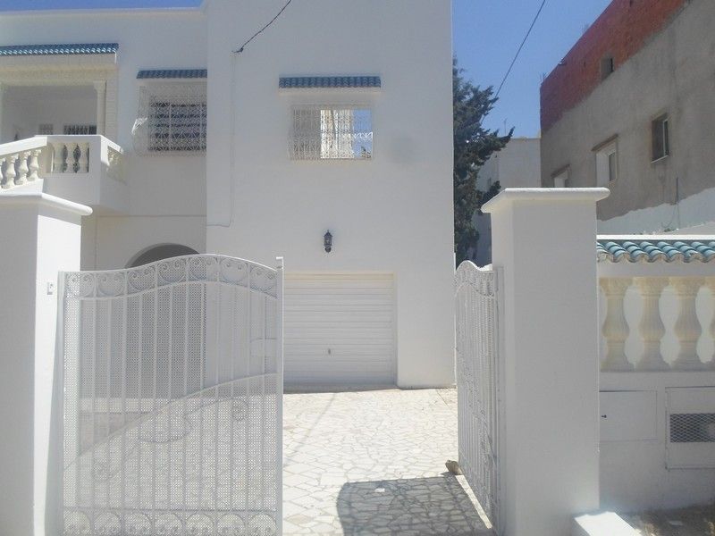 Al une belle maison au rez de chaussée avec un garage et jardin